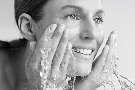 Жінка вмиває обличчя