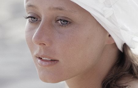 Жінка у білому головному уборі.