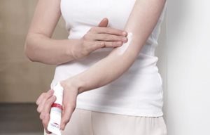 Жінка наносить Заспокійливий крем для атопічної шкіри Eucerin AtopiControl на згин руки.